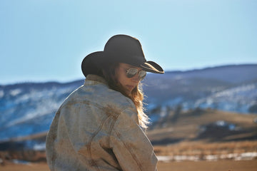 a woman wearing a cowboy hat and sunglasses