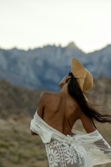 A woman in a white dress and a tan hat